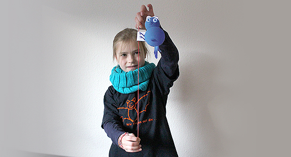 So wird der Wackle-Wutz in der Hand gehalten, und schon arbeitet er sich das Gummiband herunter.